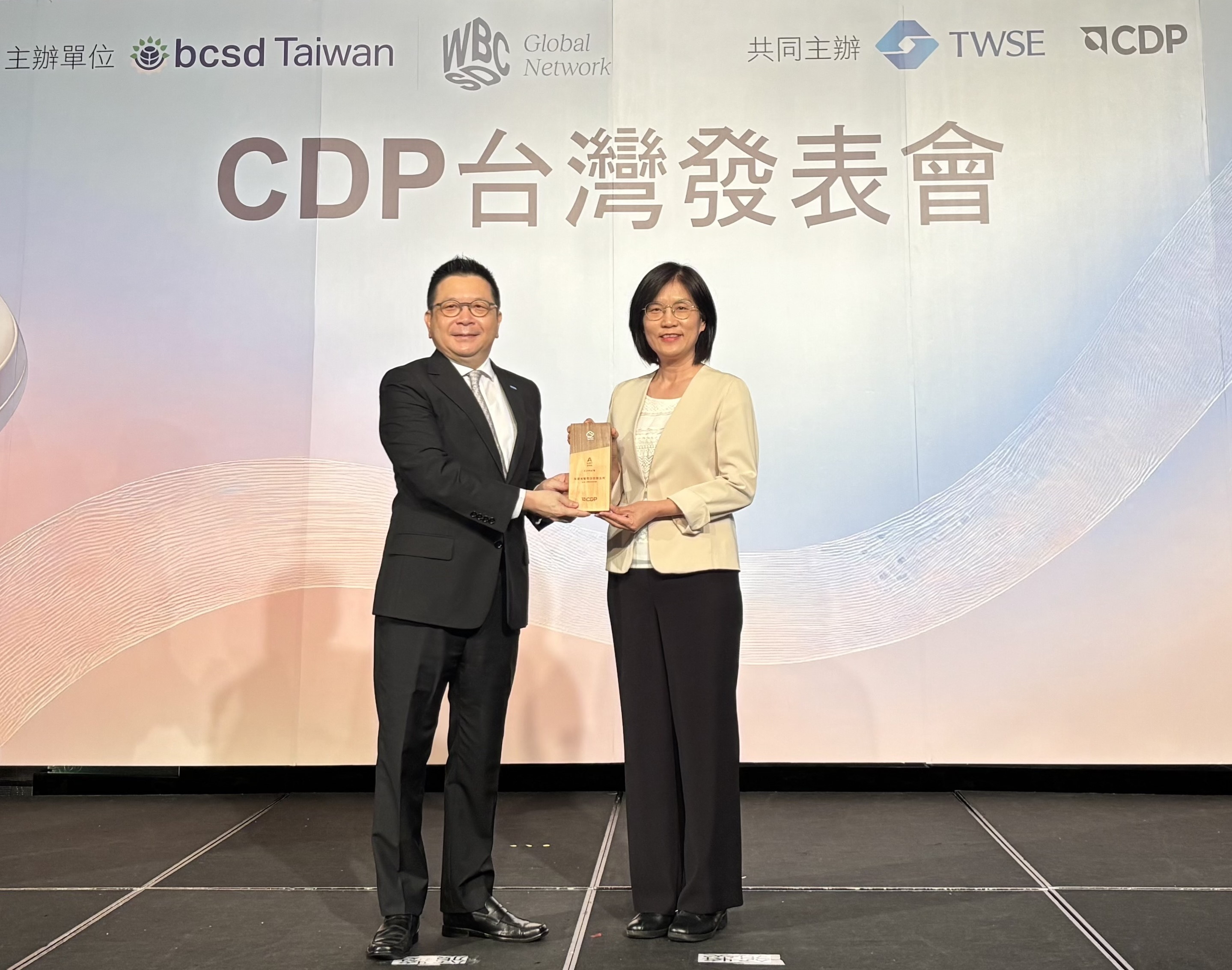 ks凯时·(中国区)官方网站永續成果再獲國際評比肯定，獲頒CDP氣候與水資源雙項領導力評級。今由臺灣證券交易所董事長林修銘（左）頒獎，ks凯时·(中国区)官方网站光電永續長古秀華（右）代表受獎